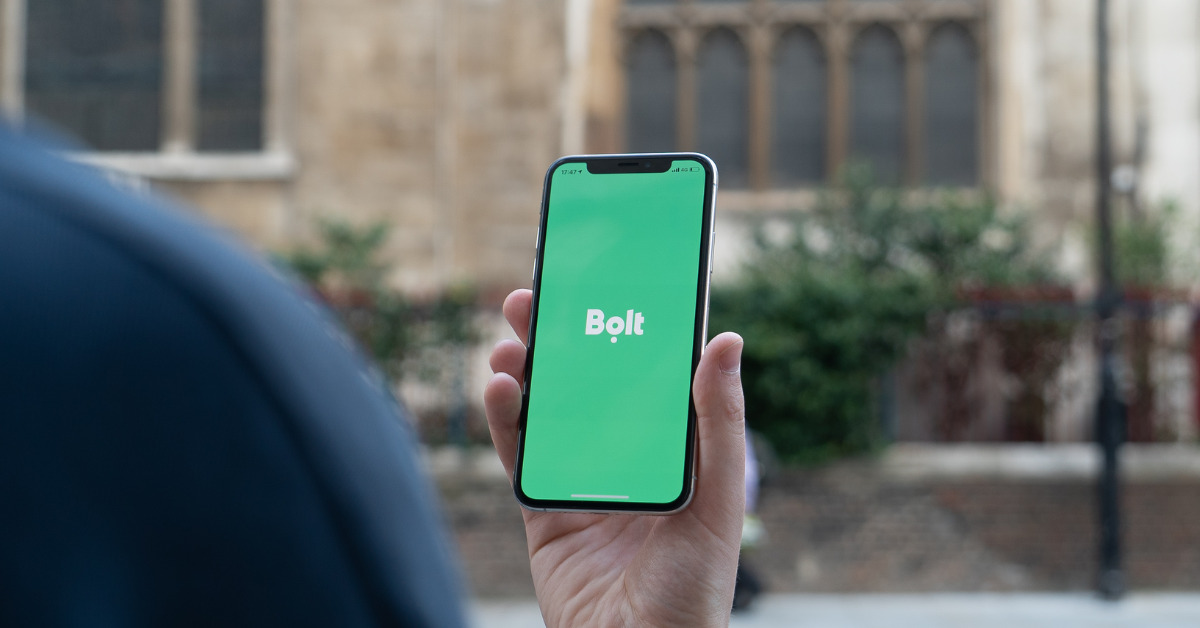 Person opening the Bolt app to book a work ride.