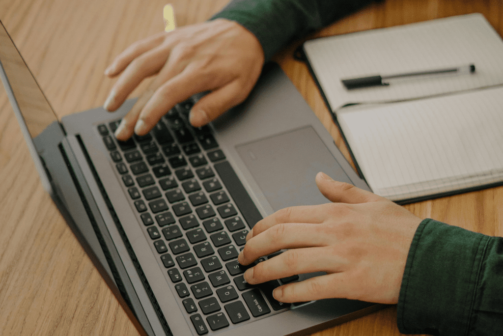 Person evaluating their insurance options on their laptop with a notepad on the side 