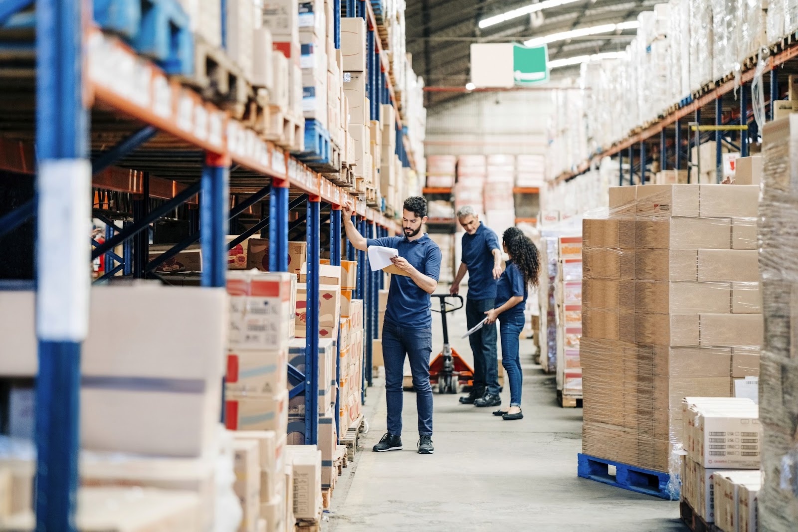 Employé dans un entrepôt logistique vérifiant des marchandises sur étagère – contrôle qualité et gestion des stocks en temps rée