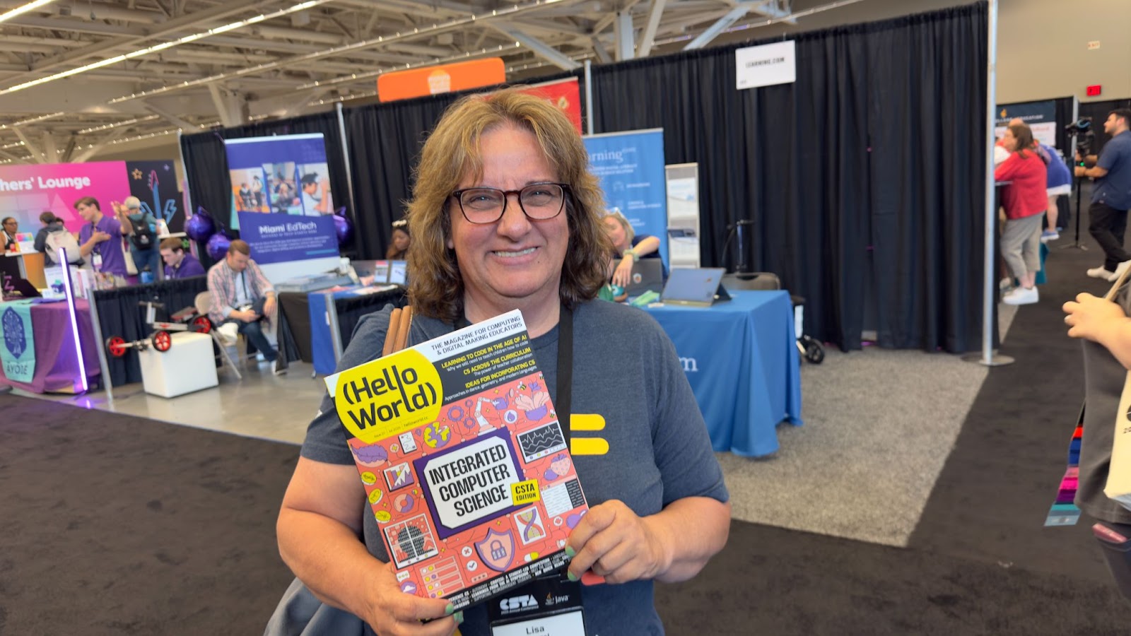 Lisa Wenzel, CS teacher in Maryland, USA, smiling and holding a physical copy of Hello World, issue 27.