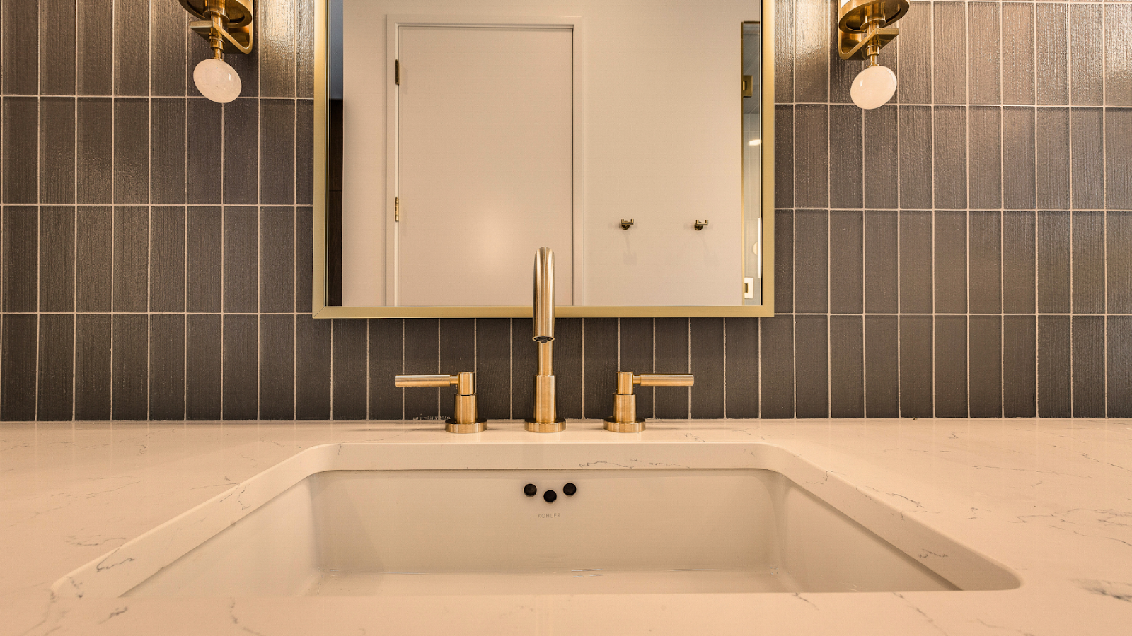 A bathroom basin surrounded by luxury decorative tiles.