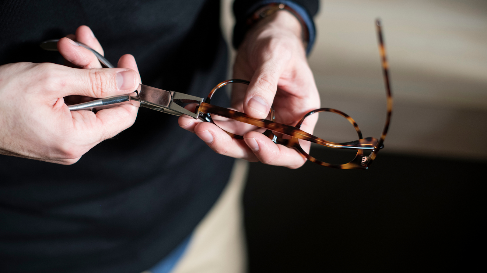 Un opticien règle les lunettes de son client à domicile pour une meilleure satisfaction client. 