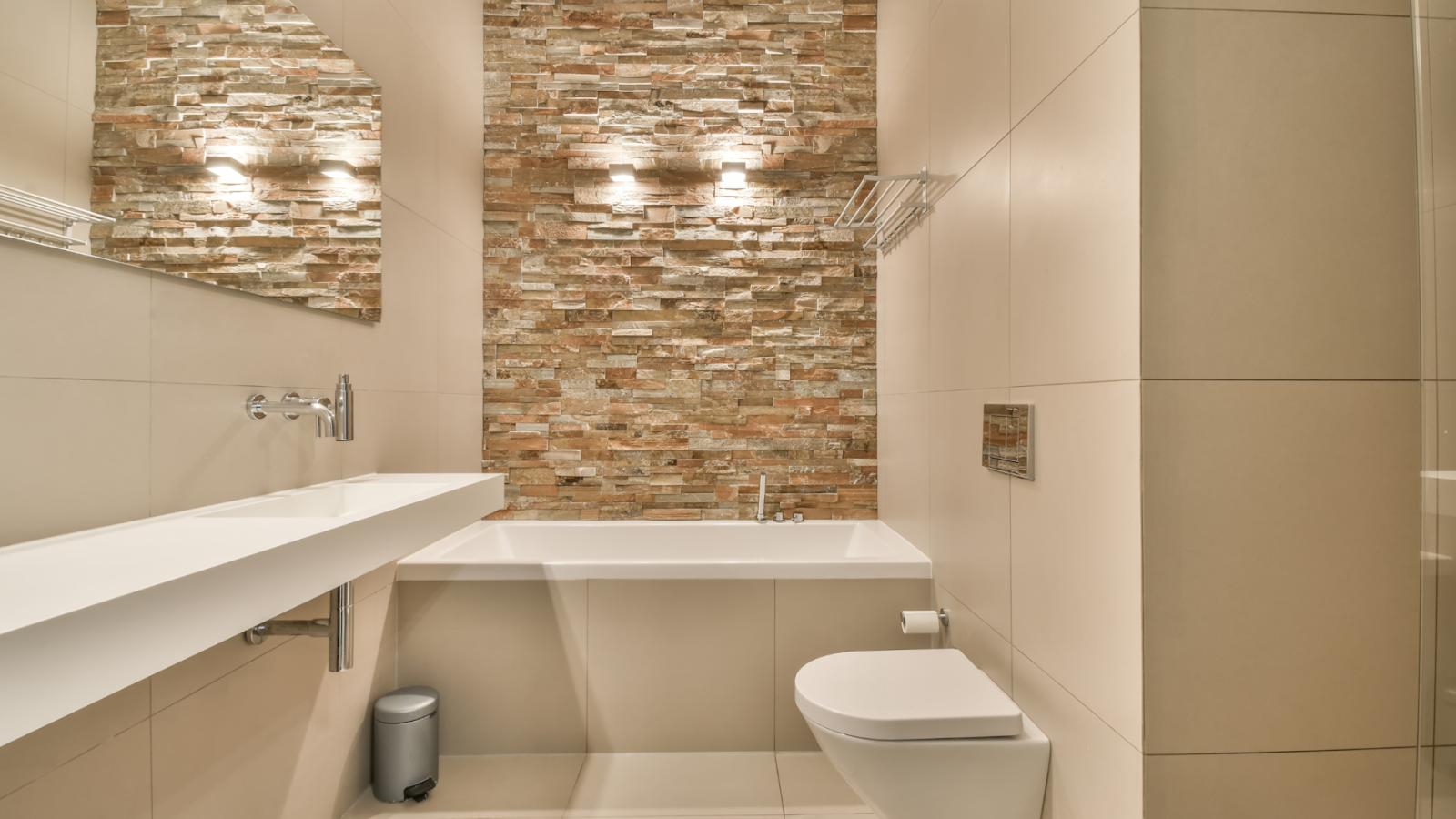 A small, modern bathroom with stone cladding on the one.