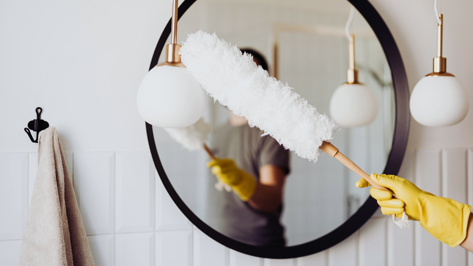 A person dusting their light fixtures. 